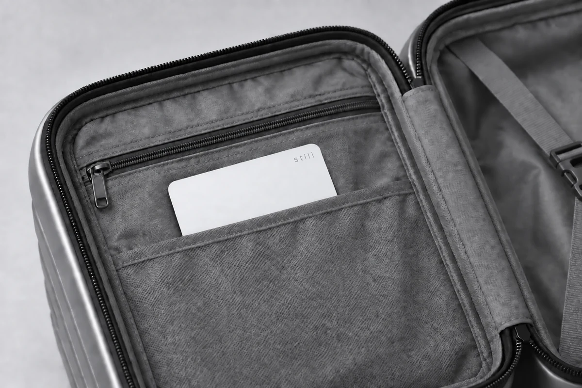 White Still Card tucked into an organizer pocket inside an open suitcase