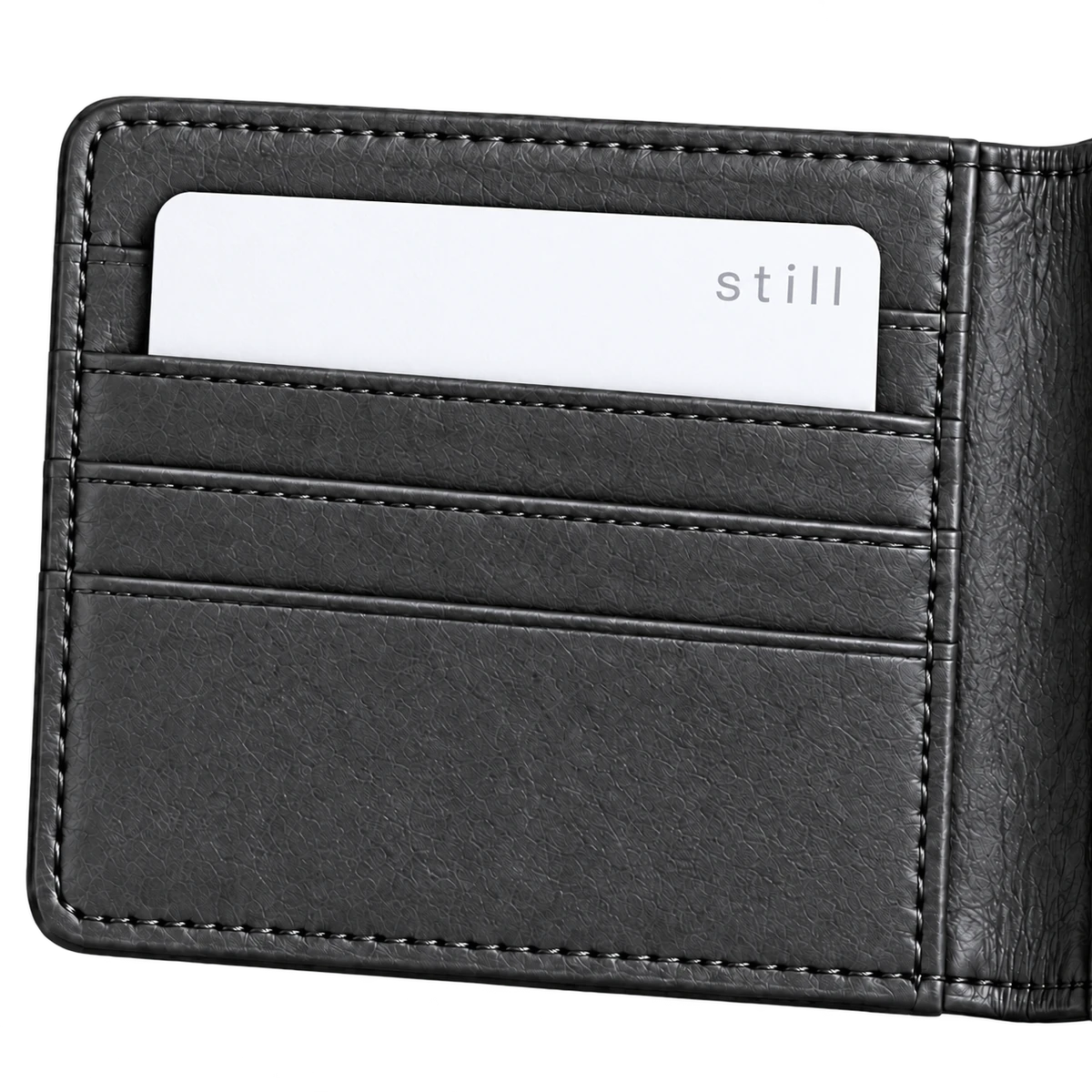 Close-up of the left half of a charcoal leather wallet holding a white Still Card